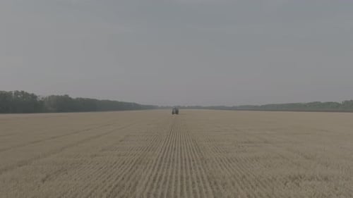 Farmer on Tractor Fertilizing Agricultural Field Spreading Mineral Fertilizer in Slow Motion Tractor