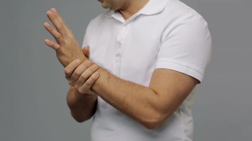 Man Massaging Wrist To Relieve Pain, Soreness