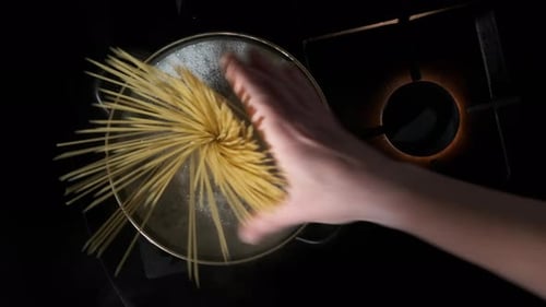 Adding Spaghetti Pasta to Boiling Water in Pot