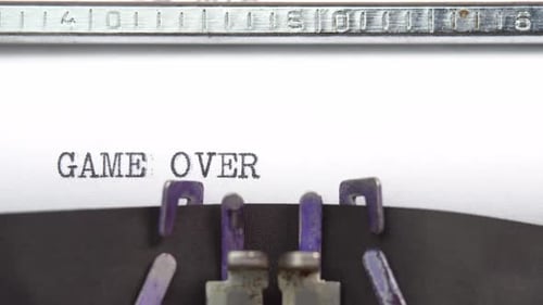 Game Over phrase closeup being typing and centered on a sheet of paper on old vintage typewriter