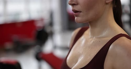 Athletic woman with sweat on her body after training in gym, closeup