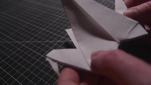 Folding a paper origami flying swan close up shot
