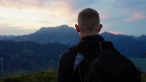 Back View Of Man Looking Towards The Mountain During Sunset