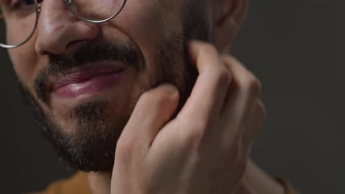 Young Man Scratching Beard Suffering from Dry Skin