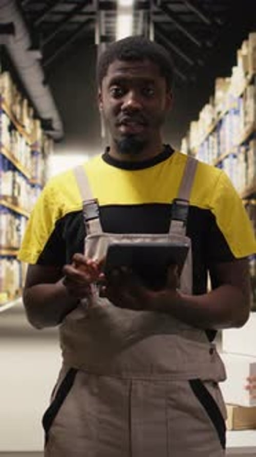 Vertical Video Black Ecommerce Worker Filming a Promotional Video Inside a Fulfillment Center