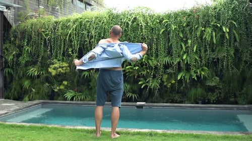 Man Taking Off Shirt and Enjoying Day in Garden 240fps