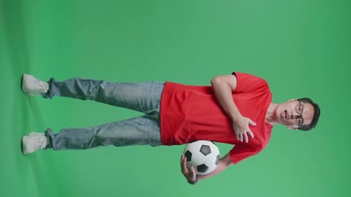 Full Body Of Asian Man With A Ball Singing National Anthem While Cheering Soccer On Green Screen