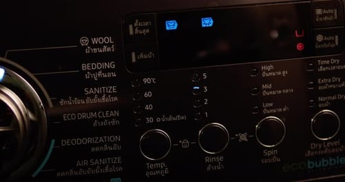 Panning slightly from the left to the right on a washing control panel showing its buttons and knobs