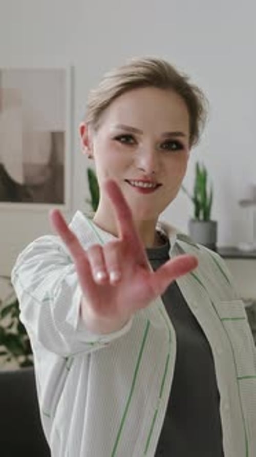 Portrait of Smiling Deaf Woman Showing I Love You in Sign Language