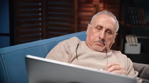 Man Relaxing on Couch with Laptop at Home