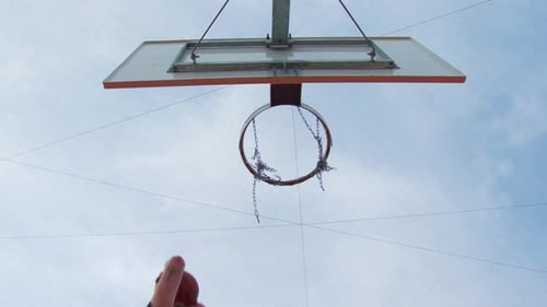 Aufnahme eines Basketballkorbs und eines Spielers, der nach dem Netz greift