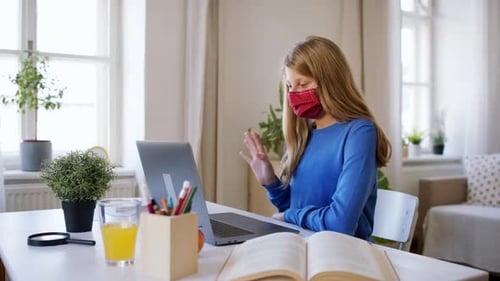 Girl learning online with red mask at home