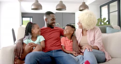 Happy Family Smiling Together on Couch at Home