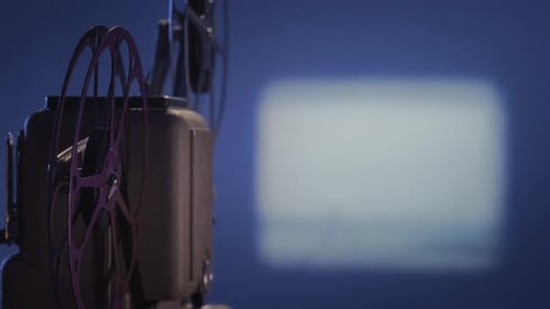 Old Film Projector Playing Movie on Screen