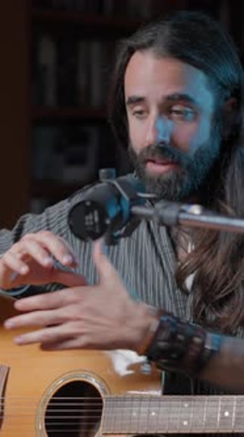 Man Plays Acoustic Guitar Indoors, sings song
