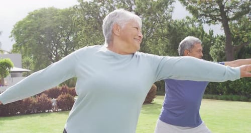 Happy senior diverse couple practicing yoga in garden