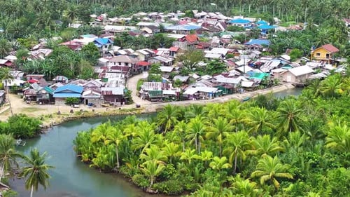 Village in tropical forest. Settlement by the river in jungle, province Siargao, Philippines. Aerial