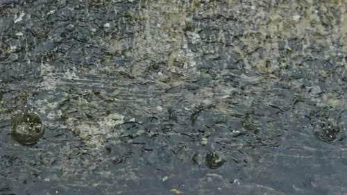 Raindrops hitting concrete ground flooded during heavy rain