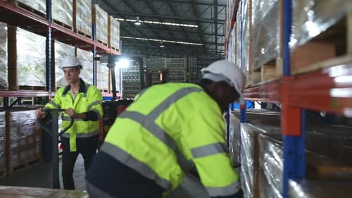 Worker in auto parts warehouse use a handcart to work to bring the box of auto parts into the storag