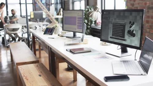 Moderne Büroräume für Unternehmen mit mehreren Schreibtischen, Computern und ungezwungener Atmosphäre