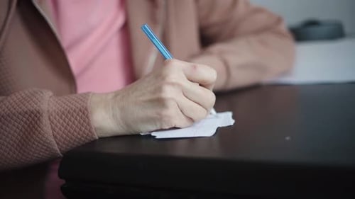 Reife Frau, Nahaufnahme, Notiz auf Papier mit blauem Stift