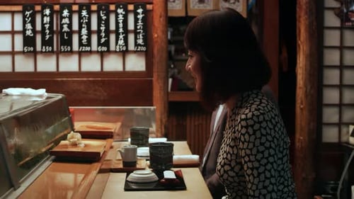 Japanese Couple Sitting At A Sushi Bar Watching The Chef Make Sushi In Small Sushi Bar With Soft ...