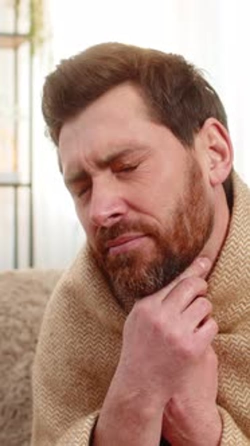 Man with Sore Throat Wrapped in Blanket