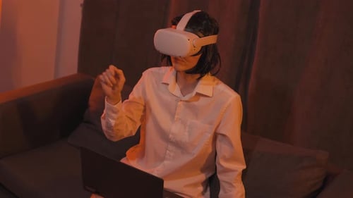 Woman Using VR Headset and Laptop at Home