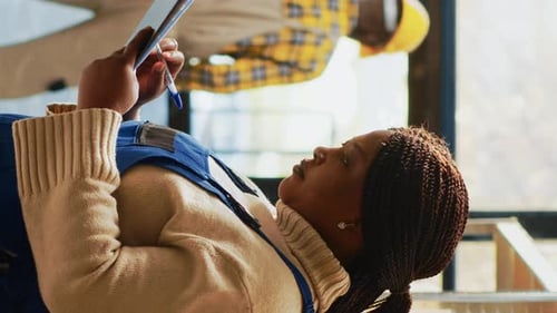 Woman Looks at Tablet in Workplace