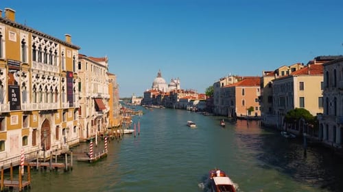 Canale Grande, the Grand canal in Venice, Italy with a boat and gondola, old houses and a cathedral