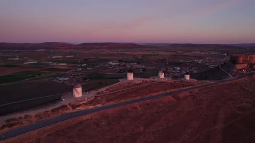 Aerial view of windmills, road, castle at sunrise, Spain.