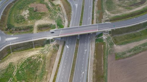 Aerial View Of Cars Driving On Elevated Road Over Empty Highway.