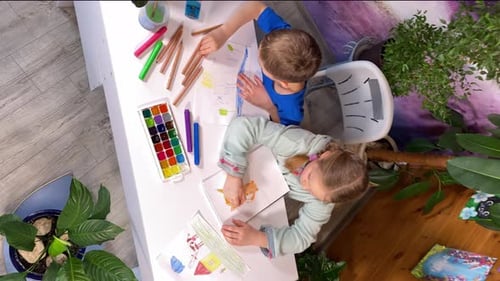 Children Drawing Together at Table Overhead View