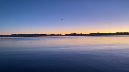 Un Drone miniature survolant le lac Tahoe au crépuscule. Tourné en HD.