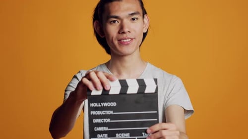 Cara animado e despreocupado usando Film Slate na câmera