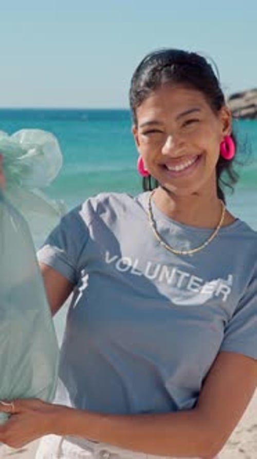Cara, voluntaria y mujer con bolsa de basura en la playa, Colleción de plástico o sostenibilidad ambiental