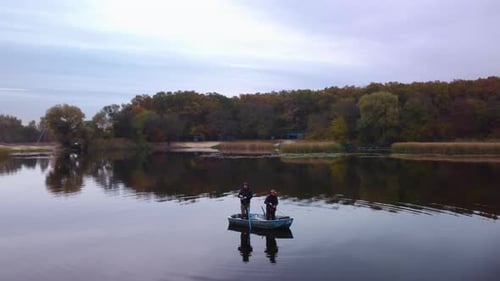 Two men are fishing in a boat on the river. autumn landscape. Aerial view.