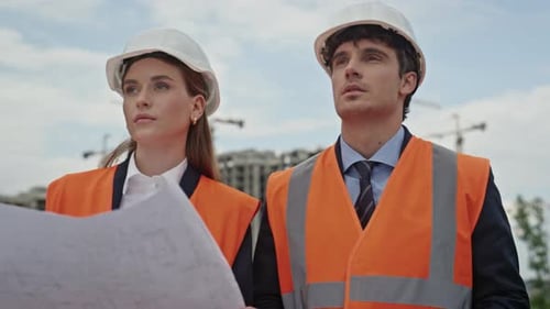 Two Engineers Study Blueprint at City Construction Site Closeup Professionals