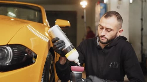 Man Applying Car Polish onto Machine Pad