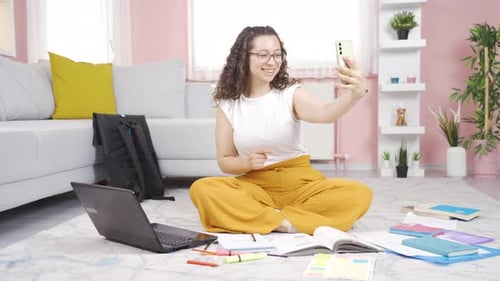 Woman taking selfie in living room with books