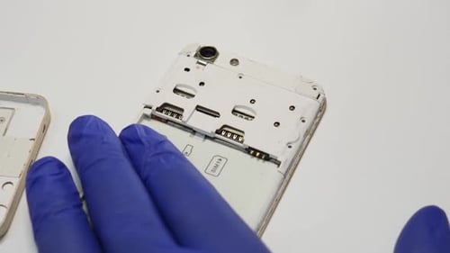 Repairing Smartphone with Gloved Hands Close Up