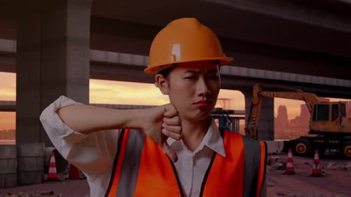 Asian Female Engineer Showing Thumbs Down Gesture And Shaking Her Head At Building Site