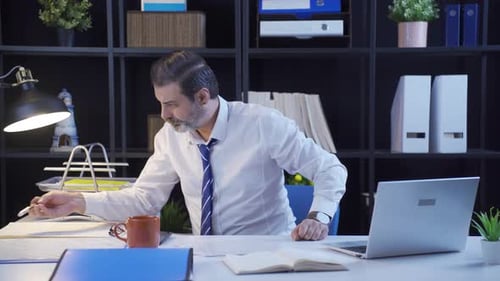 Frustrated Man Working on Laptop in Modern Office