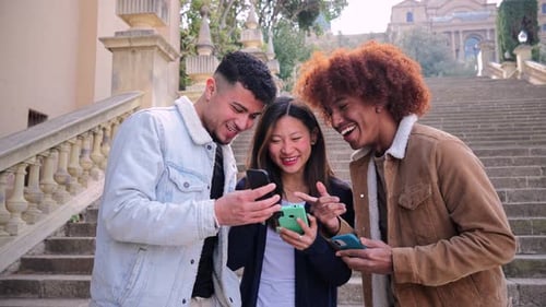 Smiling Friends Using Smartphones on City Steps