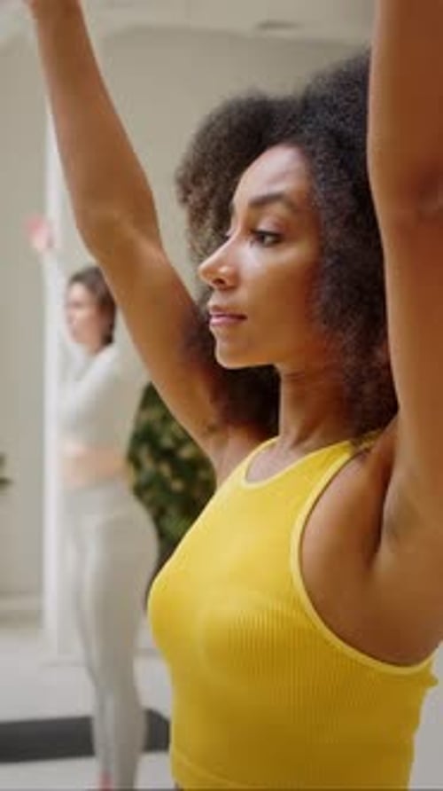 Cinco pessoas multirraciais fazendo exercícios respiratórios na academia