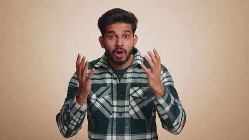 Surprised Young Man with Hands Up in Shock