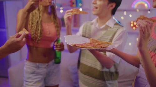 Smiling Friends Share Pizza at Indoor Get Together