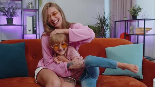 Laughing Young Adult and Child Embracing Indoors