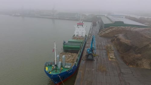 Vista aérea do guindaste terminal de madeira carregando madeira no navio de carga, Porto de Liepaja