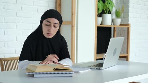 Woman Studying with Laptop and Books Indoors